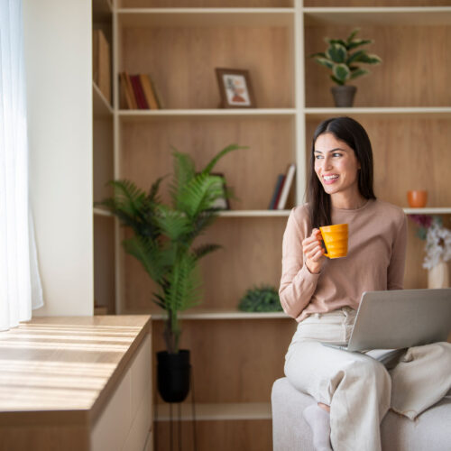 wolfcreek-condos-women-sitting-on-chair-drinking Women Sitting On Chair on Laptop